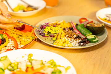 Group of Happy Asian senior women having dinner together at home. Elderly retired woman friends enjoy indoor lifestyle meeting party eating healthy food and vegetables salad together on dining table.