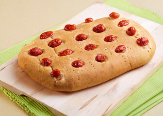 Homemade tomato focaccia bread on a cutting board