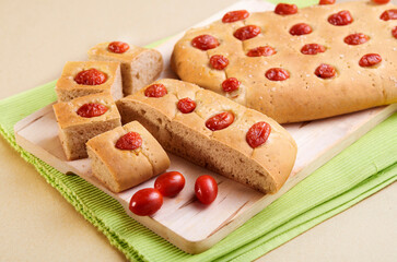 Homemade tomato focaccia bread on a cutting board