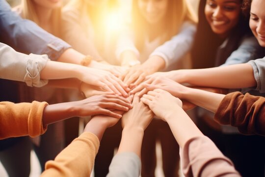 A Team of happy confident smiling young women standing in circle and putting hands together success unity adult.