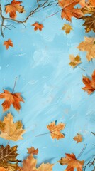 Obraz premium Autumn leaves and branches with vibrant colors framing a bright blue background, creating a seasonal border effect.