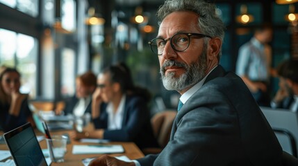 Obraz premium A boardroom filled with documents and laptops, business leaders intensely discussing terms of a major acquisition, mix of serious and determined expressions, atmosphere charged with anticipation