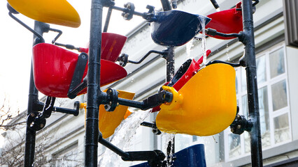 Close up of bucket water fountain spilling water on Cuba Street in capital city of Wellington, New Zealand Aotearoa © Travelanza