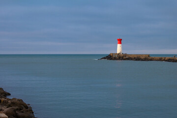 Fototapeta premium A lighthouse is on a rocky shoreline