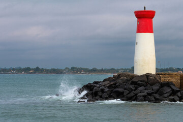 Obraz premium A lighthouse is on a rocky shoreline