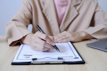 Fototapeta premium Business woman employer holding resume hiring recruit looking cv resume to hire candidates, analyzing information before job interview. Recruitment concepts