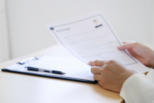 Business woman employer holding resume hiring recruit looking cv resume to hire candidates, analyzing information before job interview. Recruitment concepts