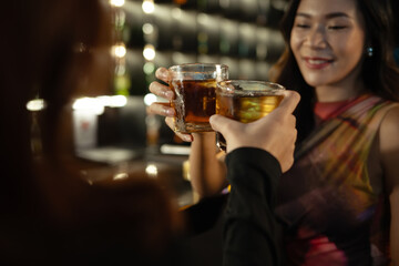 Shot of female friends toasting with drinks in the bar. Nightlife, celebrations and friendship concept