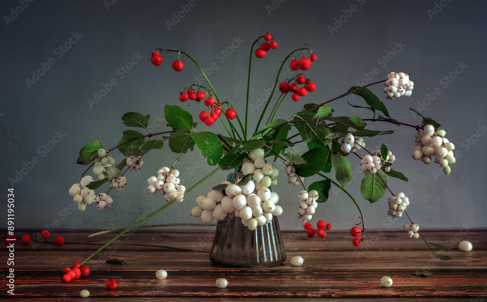 Wall mural A small bouquet of snowberry branches with berries and red lily of the valley berries.