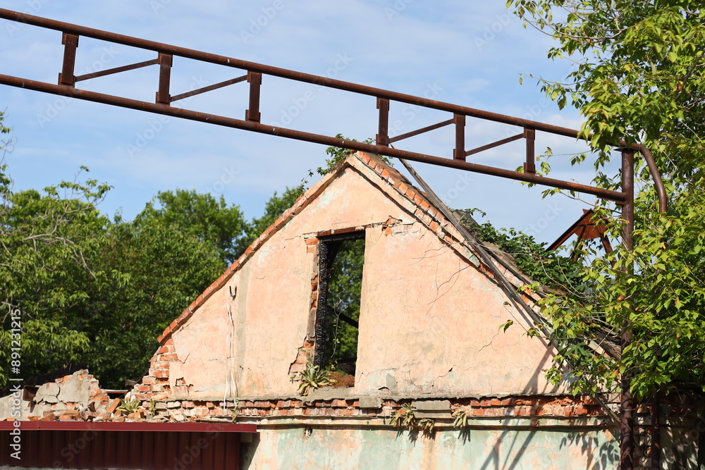 Poster a worn out old building with a broken window and a rusted roof, perfect for use in historical or aba