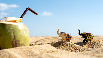 Obraz premium Elephant figurine on a sandy beach/ vacation and travel concept