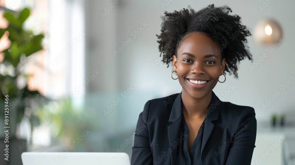 Wall mural a smiling businesswoman working on a laptop in a clean, minimalistic office