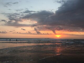 Obraz premium sunset at the beach with surfers 
