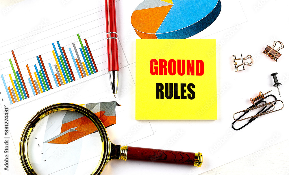 Aufkleber ground rules text on yellow sticky on chart with magnifier and pen