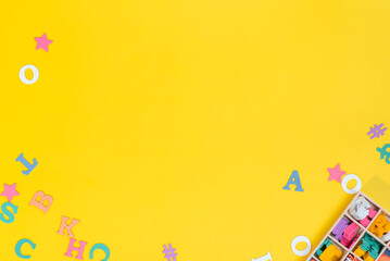 The letters of the alphabet are placed randomly on a yellow background