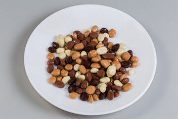 Raisins covered with dark, white and milk chocolate on dish