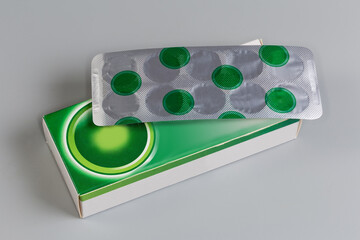 Blister of pills on its white-green cardboard box package