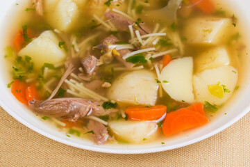 Chicken vermicelli soup in bowl, fragment close-up