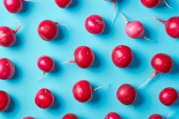 Obraz premium A close-up photograph capturing multiple red radishes spread out on a bright blue surface, emphasizing the fresh and crisp appearance of the radishes against the contrasting background.