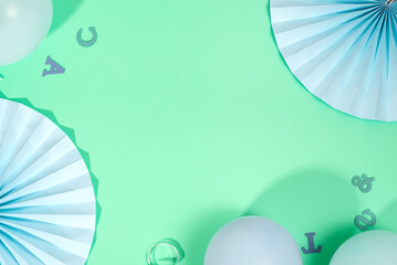 The beautiful green backdrop is decorated with paper fans and balloons