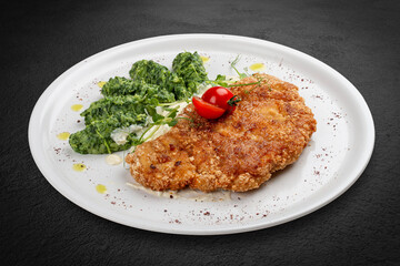 Chicken schnitzel served with sauce, accompanied by broccoli and cheese fritters.