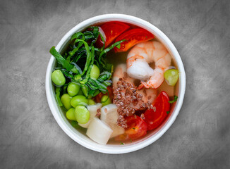 Vegetable soup with seafood. Healthly food. Takeaway food. Top view, on a gray background.
