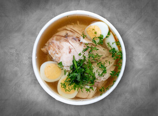 Chicken broth with quail egg. Healthy food. Takeaway food. Top view, on a gray background.