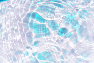 Blue water with ripples on the surface. Defocus blurred transparent blue colored clear calm water surface texture with splashes and bubbles. Water waves with shining pattern texture background.