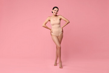 Smiling woman with perfect skin on pink background. Body care