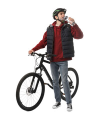 Man in helmet with bicycle drinking water on white background