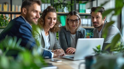 A group of people are sitting around a table with a laptop open in front of them