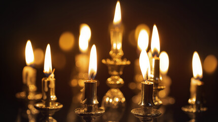 Warm glow of multiple burning candles in brass candle holders, creating a cozy, elegant atmosphere in the dark, warm light concept