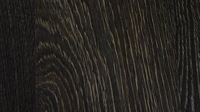 Laminate flooring in slow motion camera slide. The flooring is walnut texture, parquet on the floor