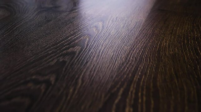 Laminate flooring in slow motion camera slide. The flooring is walnut texture, parquet on the floor.