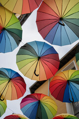 Colorful umbrellas hanging in the street. Various colorful umbrellas hanging above a street during a LGBT party