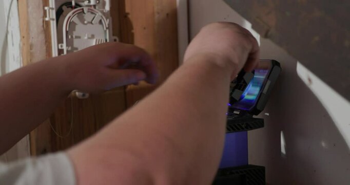 technician splicing ftth fibre glass internet cables at clients home