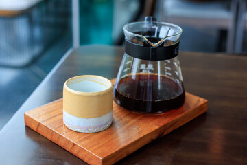 glass of coffee is poured into a glass carafe