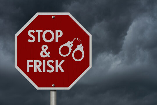  Stop and Frisk message with handcuffs on red street stop sign
