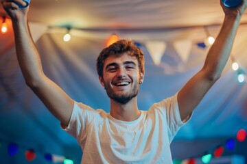 Fototapeta premium Young man celebrating with arms raised at party