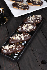 Chocolate Eclairs on White Plate with Coffee Cup: Delicious French Pastries and Hot Beverage for Gourmet Dessert or Cafe Menu Background