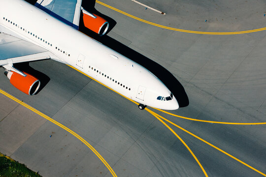 Aerial view of airplane during taxiing to runway for take off. Traffic at airport on sunny day..