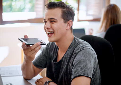 Happy man, speaker and smartphone in office for feedback, social media and online for chat. Technology, male person and smile or call in workplace for career, website or discussion for communication
