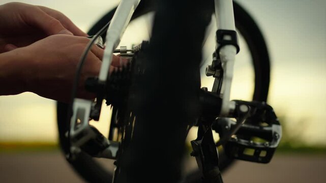 Cycling. An active cyclist on the street concentrates on using a multitool to repair his two-wheeler. The camera captures stable movement a cycling enthusiast rushes along the road