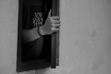 the man's hand opening the window of the house, holding the shutters of the house