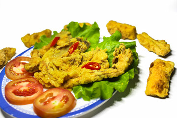 Photo of crispy fried mushroom food served on a plate and a bowl of sauce decorated with tomatoes...