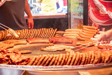 large grill filled with various types of german sausages