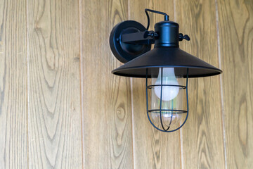 Antique electronic lamp hanging  at wooden wall in the restaurant