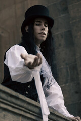 Vampire with long black hair hypnotizing with his gaze from his castle.
