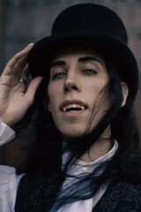 Closeup portrait of handsome gothic vampire with hat, lord of darkness