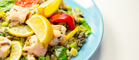 A plate of food with a piece of tuna and a lemon wedge
